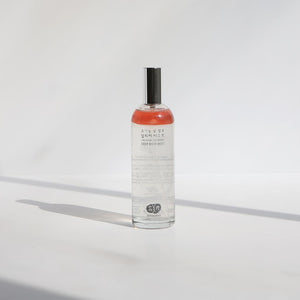 Whamisa Organic Flowers Deep Rich Mist bottled in a clear cylindrical bottle with a cap that can be easily taken off. The content is mostly clear with a layer of red pinkish oil that enriches the mist.